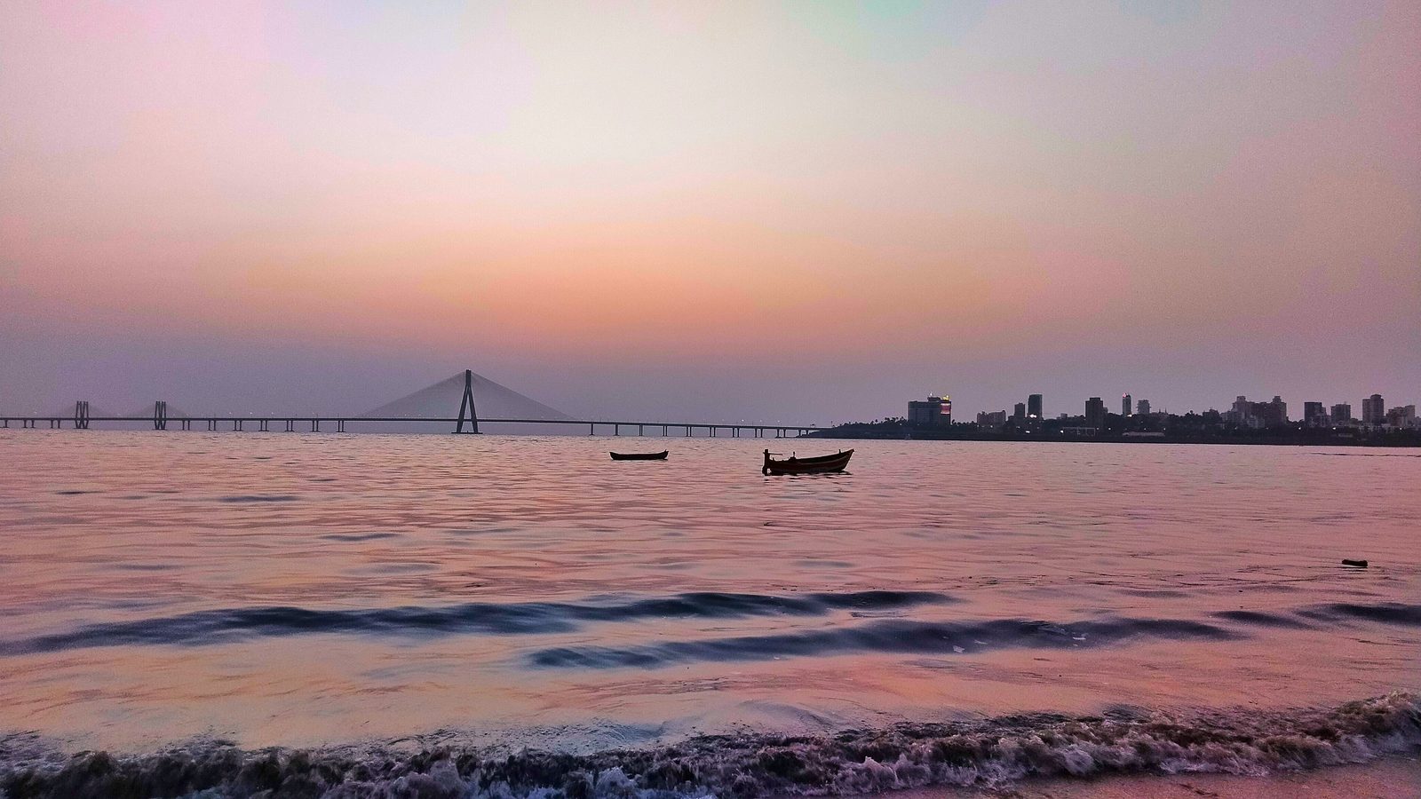 Mahim Bay at dusk with fishing boats and the Bandra-Worli Sea Link on the horizon