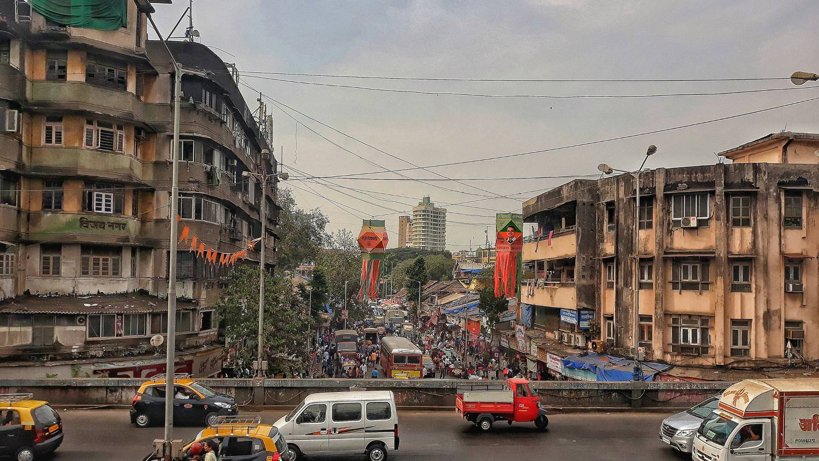 Older mid-rise buildings either side of a busy road in Dadar West